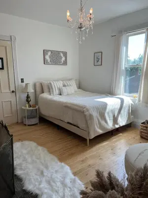 a bedroom with a bed and a chandelier at Charming Three Bedroom Retreat House in Saugerties