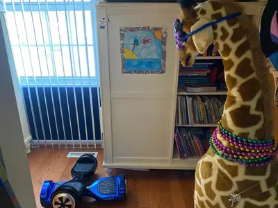 a giraffe standing next to a toy on the floor at VIP Pocono Escape Water Park,Casino,All Inclusive in East Stroudsburg