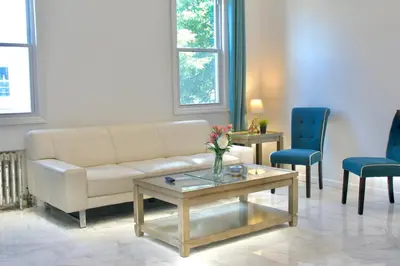 a living room with a couch and a table and chairs at 15 Minutes From Manhattan 2-Bedroom Apartment in LIC Astoria Queens