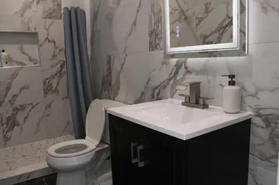 a bathroom with a sink and a toilet and a mirror at 15 Minutes From Manhattan 2-Bedroom Apartment in LIC Astoria Queens