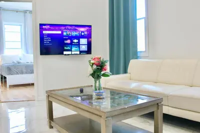 a living room with a coffee table with a vase of flowers at 15 Minutes From Manhattan 2-Bedroom Apartment in LIC Astoria Queens