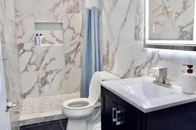 a bathroom with a toilet and a sink and a shower at 15 Minutes From Manhattan 2-Bedroom Apartment in LIC Astoria Queens