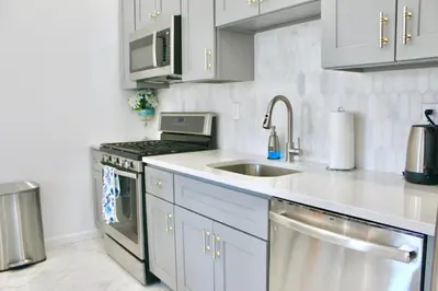 a kitchen with a sink and a stove top oven at 15 Minutes From Manhattan 2-Bedroom Apartment in LIC Astoria Queens