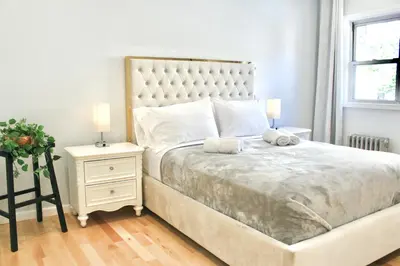 a bedroom with a large bed and a night stand at 2-Bedroom Apartment 15 Minutes From Manhattan in LIC Astoria Queens