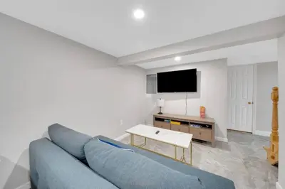 a living room with a blue couch and a tv at Cozy Cottage House - Pool & Hot Tub in Liberty