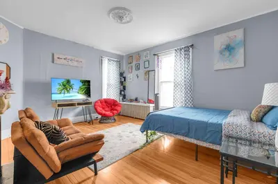 a bedroom with a bed and a couch and a tv at Historic Studio Near Trinity College with Fast WiFi in Hartford