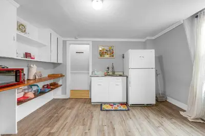 a kitchen with a white refrigerator and a wooden floor at Historic Studio Near Trinity College with Fast WiFi in Hartford