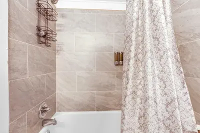 a bathroom with a shower curtain and a tub at Historic Studio Near Trinity College with Fast WiFi in Hartford