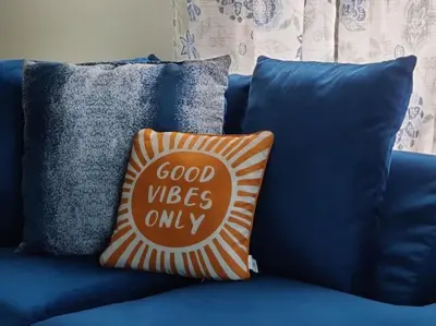 a blue couch with a pillow that says good vibes only at City Charm Walk to Trinity & Hospital with Parking in Hartford