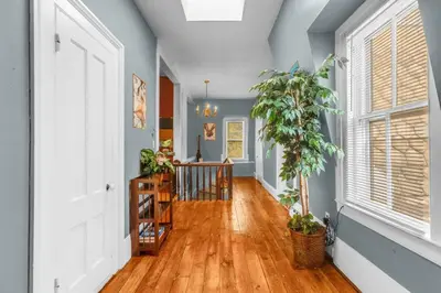 a hallway with blue walls and a hard wood floor at Enchanting 3BR Near Downtown Hartford Cozy & Modern with Parking in Hartford