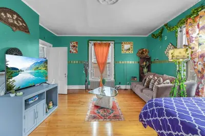 a living room with a bed and a tv at Enchanting 3BR Near Downtown Hartford Cozy & Modern with Parking in Hartford
