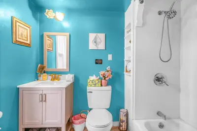 a bathroom with blue walls and a toilet and a sink at Enchanting 3BR Near Downtown Hartford Cozy & Modern with Parking in Hartford