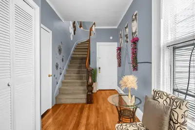 a living room with a staircase and a glass table at Enchanting 3BR Near Downtown Hartford Cozy & Modern with Parking in Hartford
