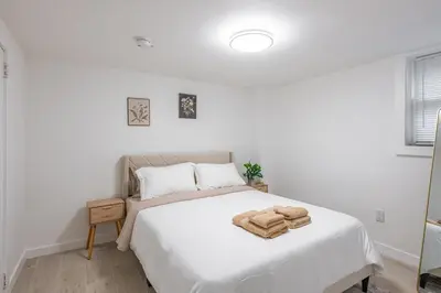 a white bedroom with a white bed with towels on it at 15m to NY Cozy Relaxing Home in Hackensack