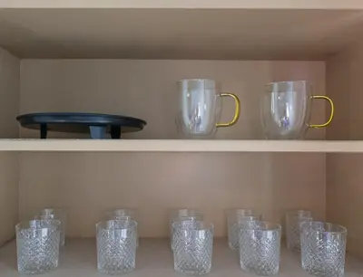 a shelf filled with glass mason jars and pitchers at Cozy Home, 19 min to NYC, 3 Car Driveway in Wallington