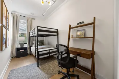 a bedroom with two bunk beds and a desk at 3BR Brownstone near Subway & Columbia Uni in New York