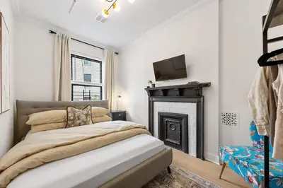 a bedroom with a bed and a fireplace at 3BR Brownstone near Subway & Columbia Uni in New York