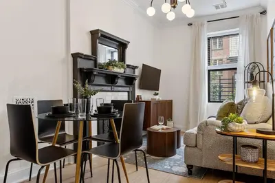 a living room with a table and chairs and a couch at 3BR Brownstone near Subway & Columbia Uni in New York