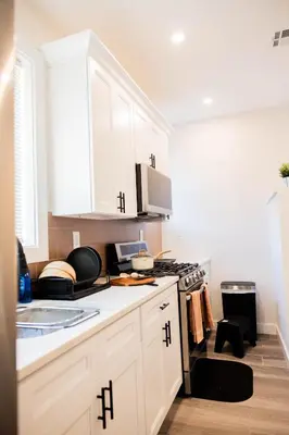a kitchen with white cabinets and a stove top oven at Joynest Place in Newark