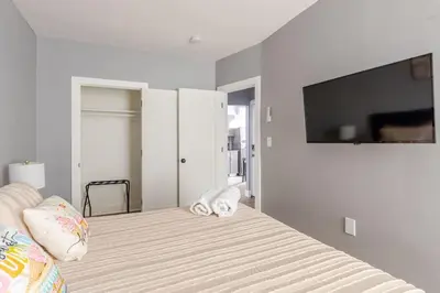 a bedroom with a bed with a tv on the wall at Modern 2 Bedroom in Black Rock in Bridgeport