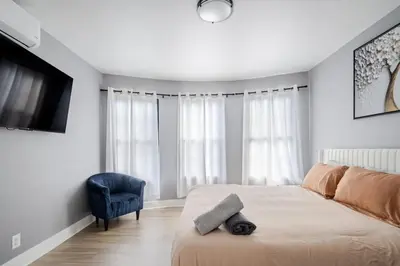 a bedroom with a bed and a tv and a chair at 3 Bedrm Apt at Black Rock Suites in Bridgeport