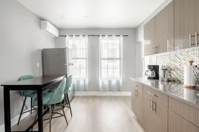 a kitchen with a table and chairs and a refrigerator at 3 Bedrm Apt at Black Rock Suites in Bridgeport
