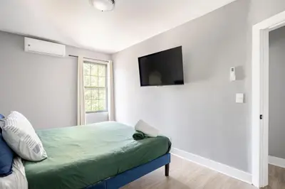 a bedroom with a bed and a tv on the wall at 3 Bedrm Apt at Black Rock Suites in Bridgeport