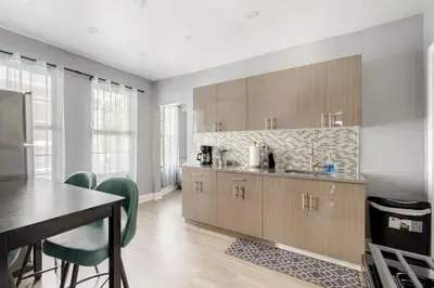 a kitchen with wooden cabinets and a table and chairs at 3 Bedrm Apt at Black Rock Suites in Bridgeport