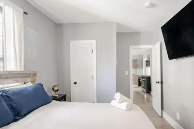 a bedroom with a white bed with blue pillows at 3 Bedrm Apt at Black Rock Suites in Bridgeport