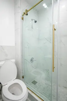 a bathroom with a toilet and a glass shower at 3 Bedrm Apt at Black Rock Suites in Bridgeport