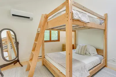 a bedroom with two bunk beds and a mirror at 13 Mi to Ski Big Bear Updated Getaway with Deck in Shohola