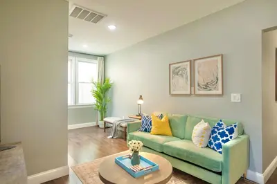 a living room with a green couch and a table at The Hillside | Full House | Parking | Near EWR-NYC in Newark