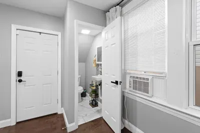 a bathroom with a white door and a window at Urban Charm | Near EWR Airport Easy Access to NYC in Newark