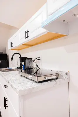 a kitchen with white cabinets and a sink at Joynest Loft - Private Entry & Bath in Newark