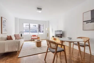 a living room with a table and a couch at Blueground Midtown East doorman nr MoMA NYC-1786 in New York