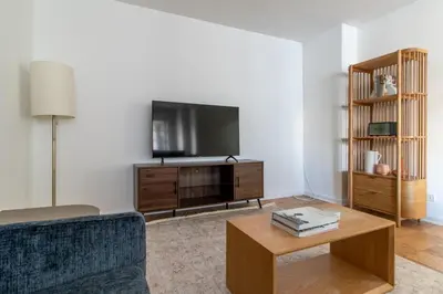a living room with a couch and a tv at Blueground Yorkville pool nr Central Park NYC-1329 in New York
