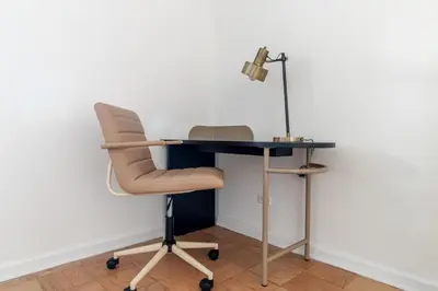 a desk with a chair and a lamp at Blueground Yorkville pool nr Central Park NYC-1329 in New York