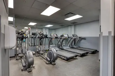 a gym with rows of tread machines in a room at Blueground Yorkville pool nr Central Park NYC-1329 in New York