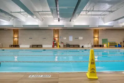 a swimming pool with a caution sign in the middle at Blueground Yorkville pool nr Central Park NYC-1329 in New York