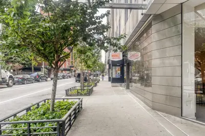 a sidewalk in front of a building with a tree at Blueground Hells Kitchen view nr Hudson River NYC-1905 in New York