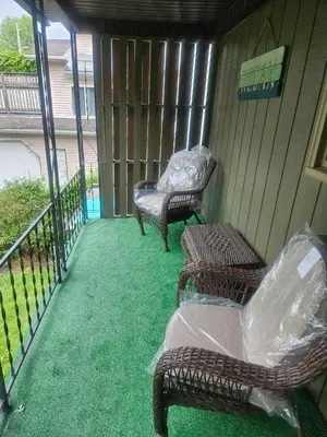 two wicker chairs and a chair on a porch at Super Comfy Entire Home in Scranton