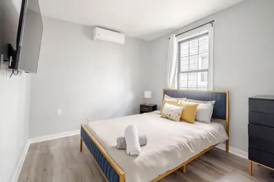 a white bedroom with a large bed and a window at Modern 2 Bed in BlackRock in Bridgeport