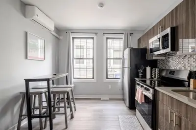 a kitchen with a refrigerator and some stools in it at Modern 2 Bed in BlackRock in Bridgeport