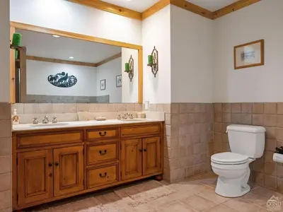 a bathroom with a toilet and a sink and a mirror at Fireplaces, Home Theater, Ski-In Out Windham Lodge in Windham