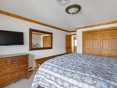 a bedroom with a bed and a flat screen tv at Fireplaces, Home Theater, Ski-In Out Windham Lodge in Windham