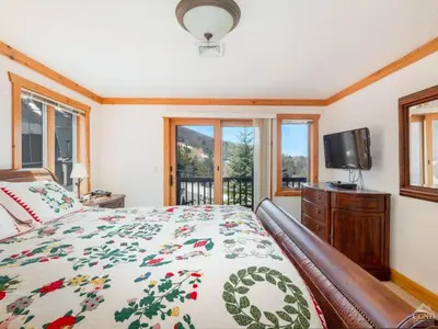 a bedroom with a bed and a tv and windows at Fireplaces, Home Theater, Ski-In Out Windham Lodge in Windham
