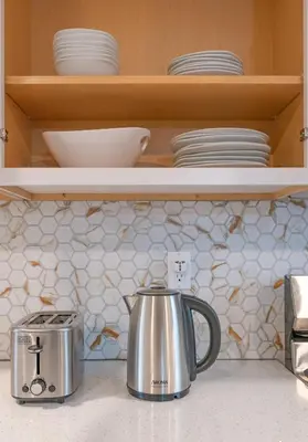 a kitchen counter with a tea kettle and plates at Cozy Home, 17 min from NYC, 2 Parking Spaces in Ridgefield Park