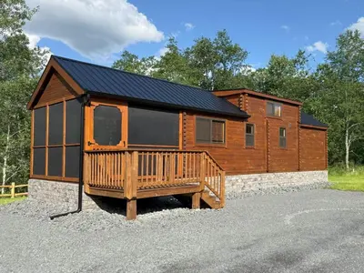 a log cabin with a porch and a house at Tiny Cabin #1 by Windham NY Escape 'Catskill Gem' in Hensonville