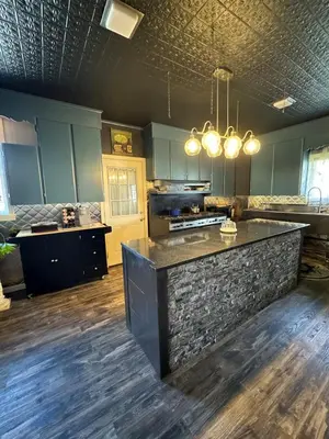 a kitchen with blue cabinets and a stone counter top at The Pulpit House