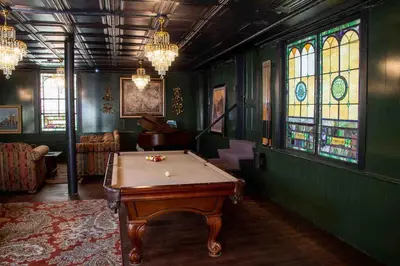 a pool table in a room with stained glass windows at The Pulpit House